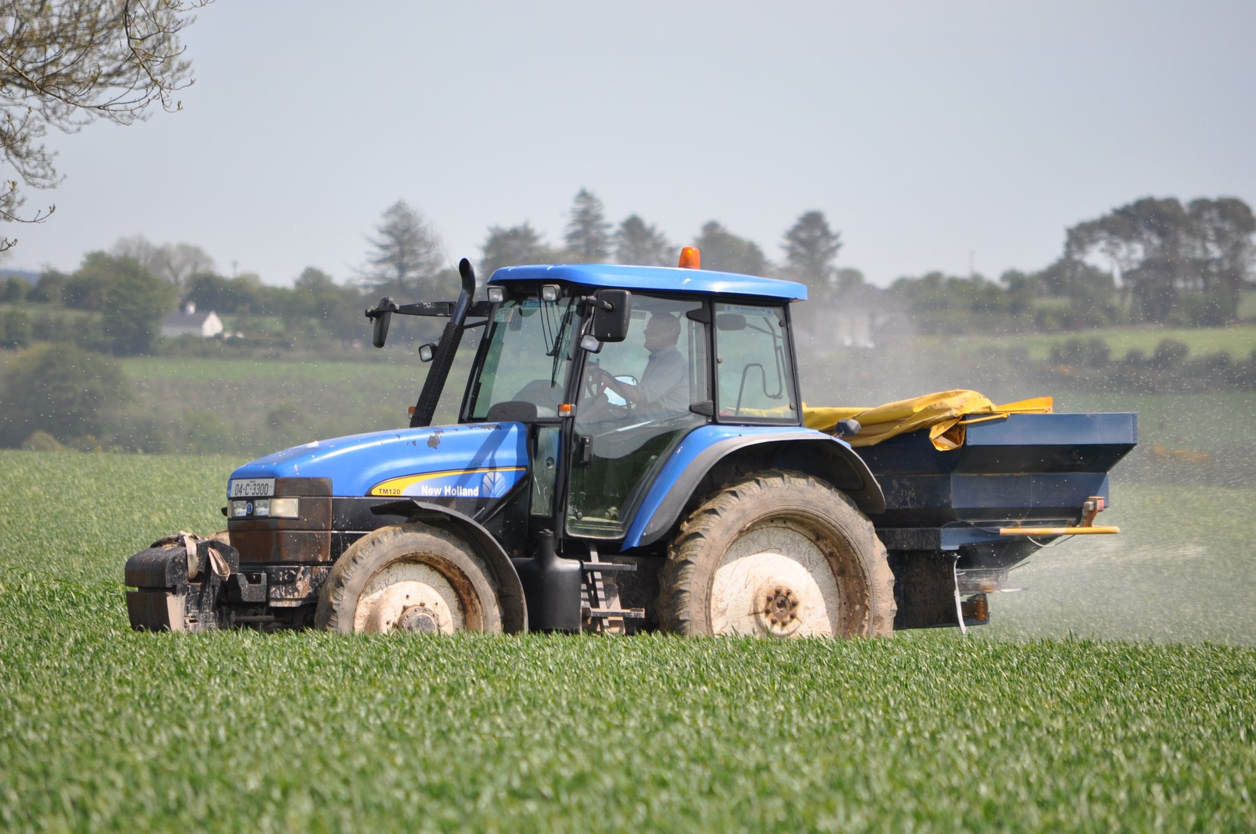 épandage d'azote sur une parcelle agricole avec un tracteur bleu new holland
